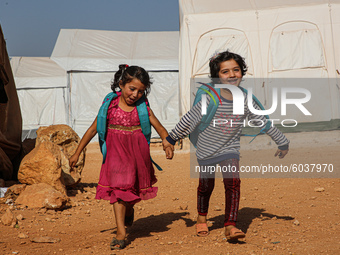 Syrian students play in front of their school tent on the first day of the new school year near the city of Maarat Misreen in Idlib countrys...