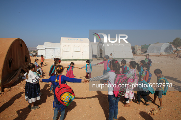 Syrian students play in front of their school tent on the first day of the new school year near the city of Maarat Misreen in Idlib countrys...