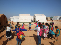 Syrian students play in front of their school tent on the first day of the new school year near the city of Maarat Misreen in Idlib countrys...