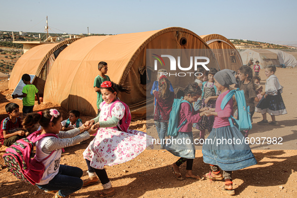 Syrian students play in front of their school tent on the first day of the new school year near the city of Maarat Misreen in Idlib countrys...