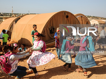 Syrian students play in front of their school tent on the first day of the new school year near the city of Maarat Misreen in Idlib countrys...