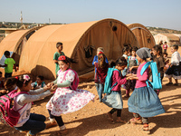 Syrian students play in front of their school tent on the first day of the new school year near the city of Maarat Misreen in Idlib countrys...