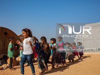 Syrian students play in front of their school tent on the first day of the new school year near the city of Maarat Misreen in Idlib countrys...