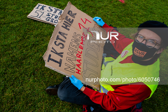 A Dutch student is writing a placard in representation of other students during the students protest for more physical attendance classes, i...