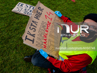 A Dutch student is writing a placard in representation of other students during the students protest for more physical attendance classes, i...