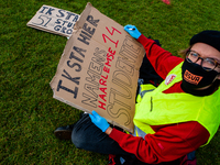 A Dutch student is writing a placard in representation of other students during the students protest for more physical attendance classes, i...