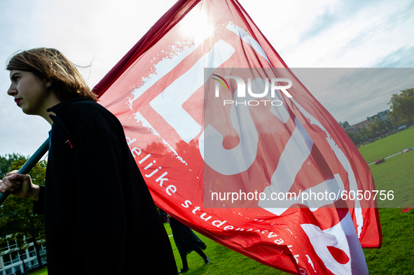 A student is carrying a flag of one of the student syndicates, during the students protest for more physical attendance classes, in Amsterda...