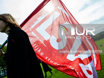 A student is carrying a flag of one of the student syndicates, during the students protest for more physical attendance classes, in Amsterda...