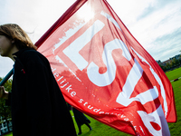 A student is carrying a flag of one of the student syndicates, during the students protest for more physical attendance classes, in Amsterda...