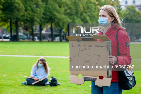 A woman is holding a placard in representation of other students during the students protest for more physical attendance classes, in Amster...