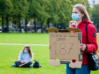 A woman is holding a placard in representation of other students during the students protest for more physical attendance classes, in Amster...