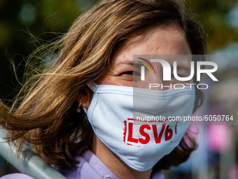 A woman is wearing a mouth mask with the logo of one of the student syndicates, during the students protest for more physical attendance cla...