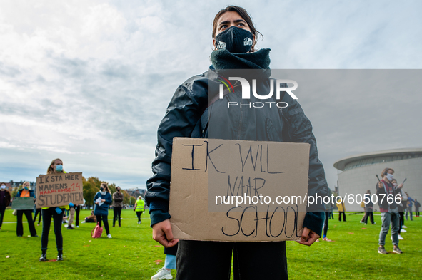 A woman is holding a placard that says I want back to school, during the students protest for more physical attendance classes, in Amsterdam...