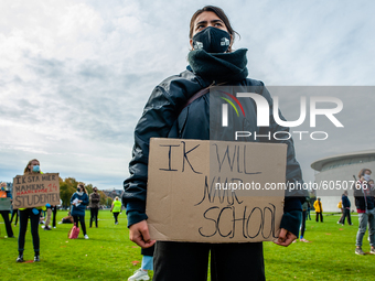 A woman is holding a placard that says I want back to school, during the students protest for more physical attendance classes, in Amsterdam...