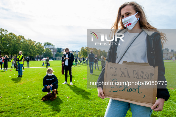 A woman is holding a placard that says I want back to school, during the students protest for more physical attendance classes, in Amsterdam...