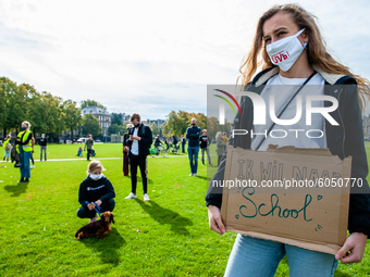 A woman is holding a placard that says I want back to school, during the students protest for more physical attendance classes, in Amsterdam...