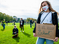 A woman is holding a placard that says I want back to school, during the students protest for more physical attendance classes, in Amsterdam...