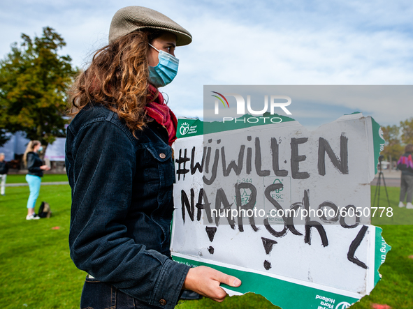 A woman is holding a placard that says I want back to school, during the students protest for more physical attendance classes, in Amsterdam...