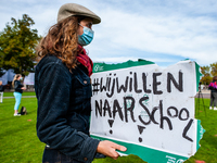 A woman is holding a placard that says I want back to school, during the students protest for more physical attendance classes, in Amsterdam...