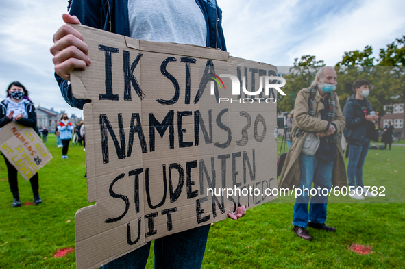 A male student is holding a placard in representation of other students during the students protest for more physical attendance classes, in...