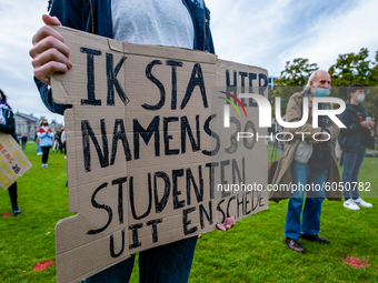 A male student is holding a placard in representation of other students during the students protest for more physical attendance classes, in...