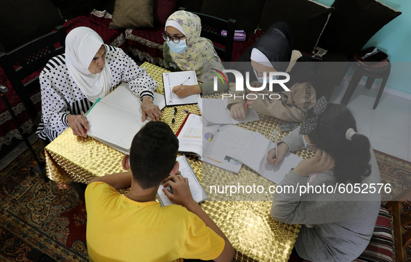 Palestinian teacher Ekram el-astal, 80, teaches her neighbours' students an Maths language lesson as schools are shut due to the coronavirus...