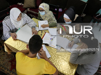 Palestinian teacher Ekram el-astal, 80, teaches her neighbours' students an Maths language lesson as schools are shut due to the coronavirus...