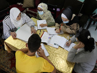 Palestinian teacher Ekram el-astal, 80, teaches her neighbours' students an Maths language lesson as schools are shut due to the coronavirus...