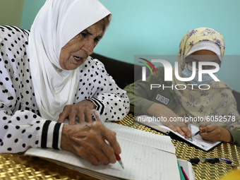 Palestinian teacher Ekram el-astal, 80, teaches her neighbours' students an Maths language lesson as schools are shut due to the coronavirus...