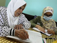 Palestinian teacher Ekram el-astal, 80, teaches her neighbours' students an Maths language lesson as schools are shut due to the coronavirus...