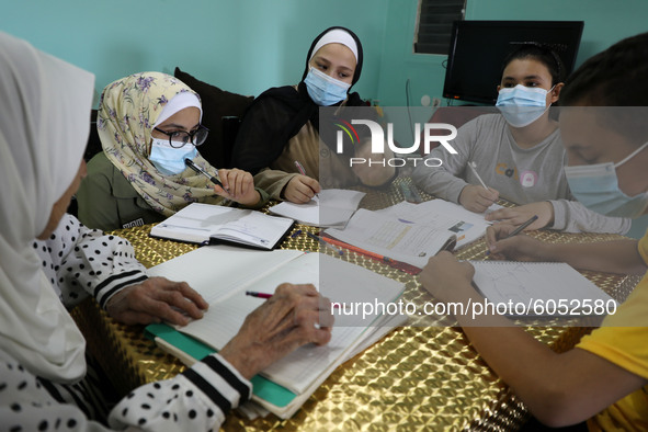 Palestinian teacher Ekram el-astal, 80, teaches her neighbours' students an Maths language lesson as schools are shut due to the coronavirus...