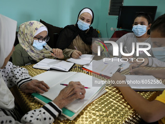 Palestinian teacher Ekram el-astal, 80, teaches her neighbours' students an Maths language lesson as schools are shut due to the coronavirus...