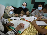 Palestinian teacher Ekram el-astal, 80, teaches her neighbours' students an Maths language lesson as schools are shut due to the coronavirus...