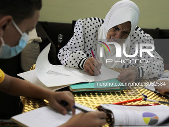 Palestinian teacher Ekram el-astal, 80, teaches her neighbours' students an Maths language lesson as schools are shut due to the coronavirus...