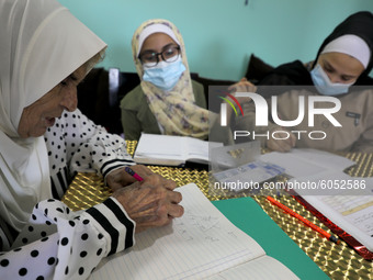 Palestinian teacher Ekram el-astal, 80, teaches her neighbours' students an Maths language lesson as schools are shut due to the coronavirus...