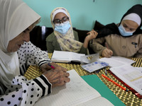 Palestinian teacher Ekram el-astal, 80, teaches her neighbours' students an Maths language lesson as schools are shut due to the coronavirus...