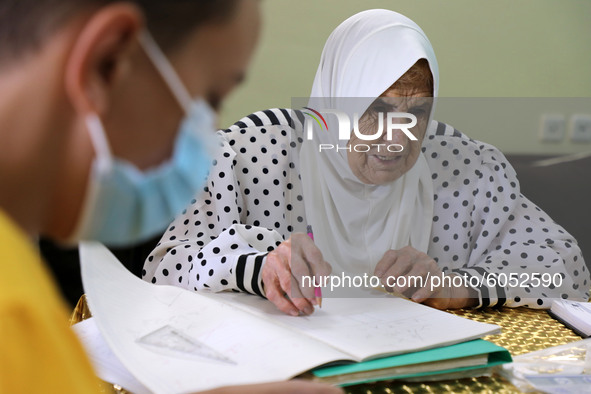 Palestinian teacher Ekram el-astal, 80, teaches her neighbours' students an Maths language lesson as schools are shut due to the coronavirus...