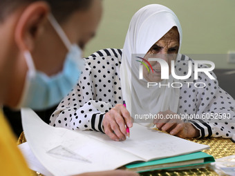 Palestinian teacher Ekram el-astal, 80, teaches her neighbours' students an Maths language lesson as schools are shut due to the coronavirus...