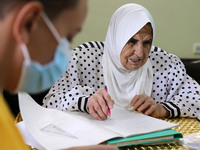 Palestinian teacher Ekram el-astal, 80, teaches her neighbours' students an Maths language lesson as schools are shut due to the coronavirus...