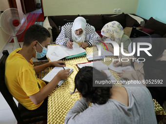 Palestinian teacher Ekram el-astal, 80, teaches her neighbours' students an Maths language lesson as schools are shut due to the coronavirus...