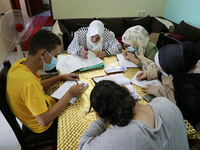 Palestinian teacher Ekram el-astal, 80, teaches her neighbours' students an Maths language lesson as schools are shut due to the coronavirus...