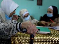 Palestinian teacher Ekram el-astal, 80, teaches her neighbours' students an Maths language lesson as schools are shut due to the coronavirus...