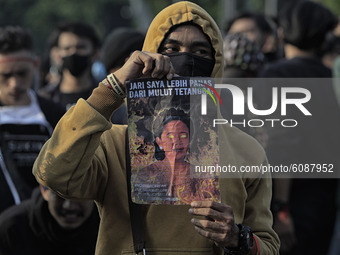 A Indonesian student holds a poster, the speaker of the Indonesian Parliament, during a demonstration against a new Indonesian labour law pa...