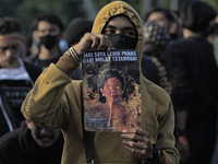 A Indonesian student holds a poster, the speaker of the Indonesian Parliament, during a demonstration against a new Indonesian labour law pa...