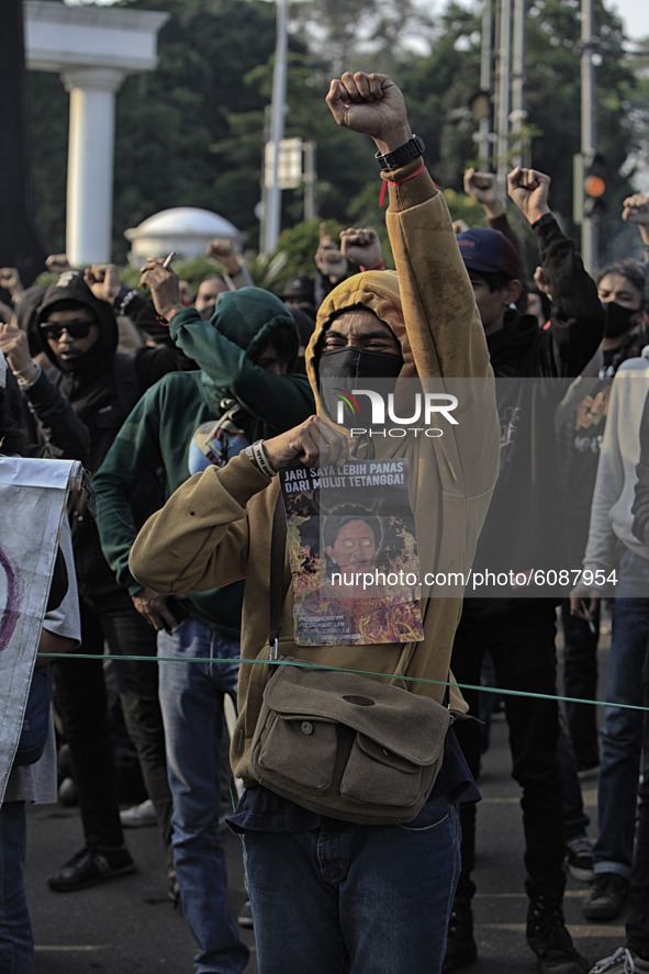 A Indonesian student holds a poster, the speaker of the Indonesian Parliament, during a demonstration against a new Indonesian labour law pa...