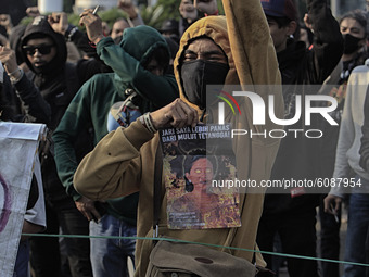 A Indonesian student holds a poster, the speaker of the Indonesian Parliament, during a demonstration against a new Indonesian labour law pa...