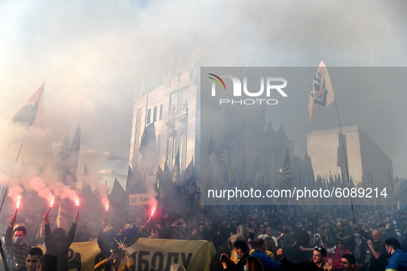 Veterans, activists and supporters of Ukraine's nationalist movements, light flares during a procession to mark the Defender of Ukraine Day...