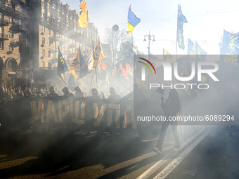 Veterans, activists and supporters of Ukraine's nationalist movements light flares during a procession to mark the Defender of Ukraine Day a...