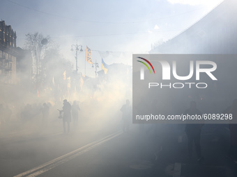 Veterans, activists and supporters of Ukraine's nationalist movements light flares during a procession to mark the Defender of Ukraine Day a...