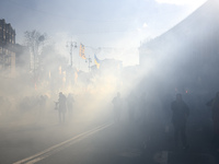 Veterans, activists and supporters of Ukraine's nationalist movements light flares during a procession to mark the Defender of Ukraine Day a...